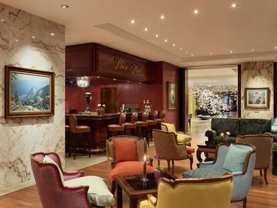 Elegantes Restaurant mit farbigen Sesseln, Marmorwänden und stimmungsvoller Beleuchtung.