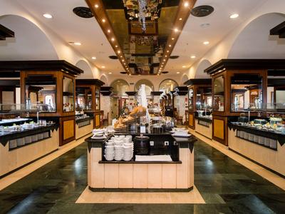 Elegant buffet with warm lighting and a variety of food options in a luxurious setting.