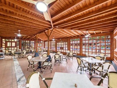 Restaurante luminoso y espacioso con techo de vigas de madera y muchas ventanas.