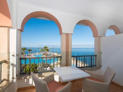 Balcon avec des arches blanches surplombant la mer par une journée ensoleillée.