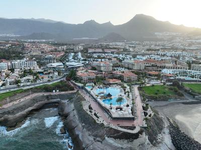Vue aérienne d'une station balnéaire avec piscine et montagnes au coucher du soleil