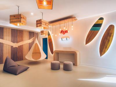 Chambre moderne et confortable avec siège suspendu, coussins et un mur incurvé avec des miroirs encastrés.