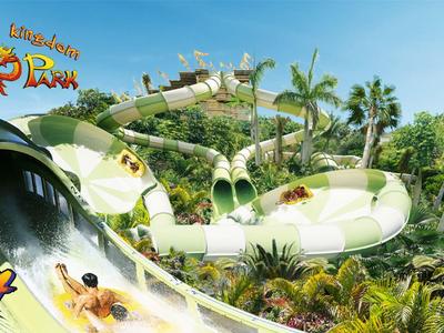 Waterpark met grote glijbanen en veel palmbomen onder een heldere hemel