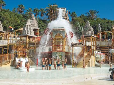Waterpark met meerdere glijbanen en watervallen voor een oud tempelthema gebouw.