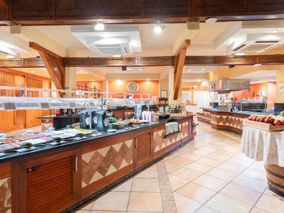 Großer Buffetbereich mit Holztheken, warmem Licht und verschiedenen Speiseangeboten.