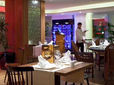 Elegancka restauracja z nakrytymi stołami i kelnerem w tle.