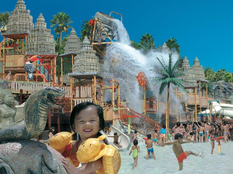 Zone aquatique animée avec toboggans, châteaux d'eau et enfants s'amusant.