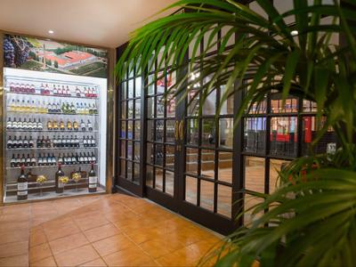 Regał z winem i szampanem obok szklanego przesuwnego wejścia w hotelu.