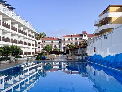 Hotelpool mit umgebenden Gebäuden und klarem Himmel