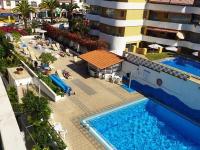 Hotelanlage mit Schwimmbad, Poolbar, Liegestühlen und umgeben von mehrstöckigen Gebäuden.