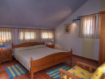 Cozy bedroom with wooden furniture, double bed, and warm tones.