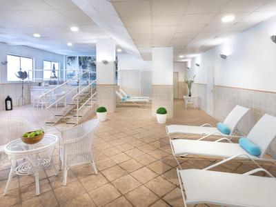Espace bien-être moderne avec transats, petites tables et éclairage lumineux.