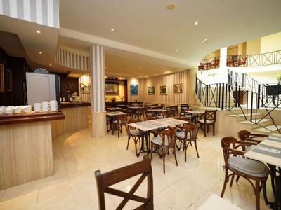 Helles, modernes Restaurant mit Holztischen und Stühlen und eleganter Treppe im Hintergrund