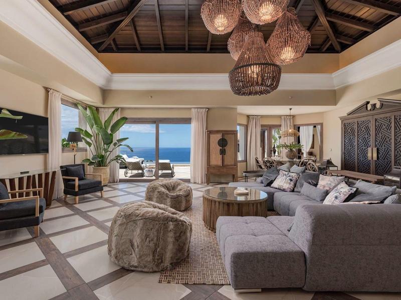 Světý obývací pokoj s výhledem na moře, moderním nábytkem a přírodní výzdobou