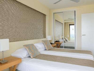 Modernes Hotelzimmer mit zwei Einzelbetten, beiger Dekoration und großem Spiegel