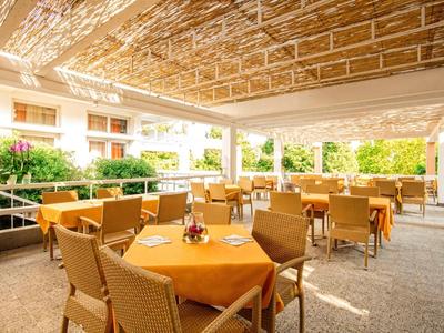 Salon extérieur couvert avec tables et chaises dans un cadre hôtelier