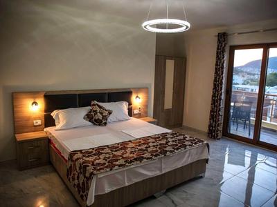 Gemütliches Schlafzimmer mit Doppelbett, modernen Lampen, Balkon und Blick auf die Berge.