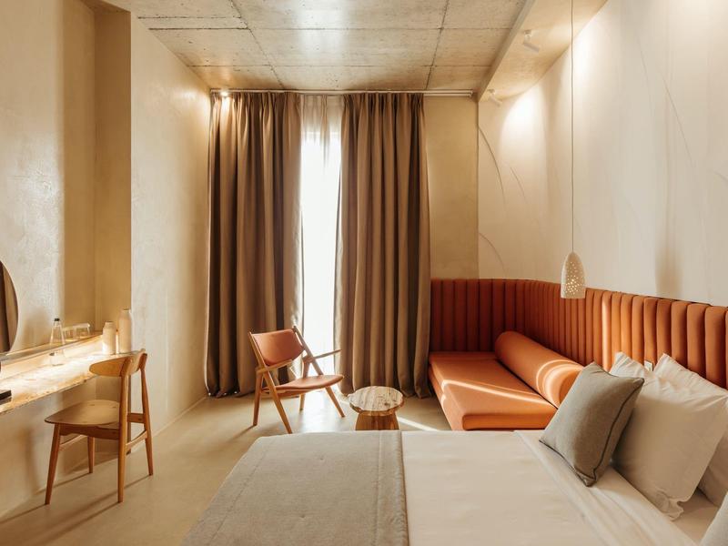 Modernes Schlafzimmer mit großen Fenstern, Vorhängen, orangefarbenem Sofa und Holzvertäfelung.