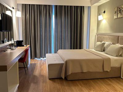 Camera d'hotel moderna con letto matrimoniale, scrivania e televisione.