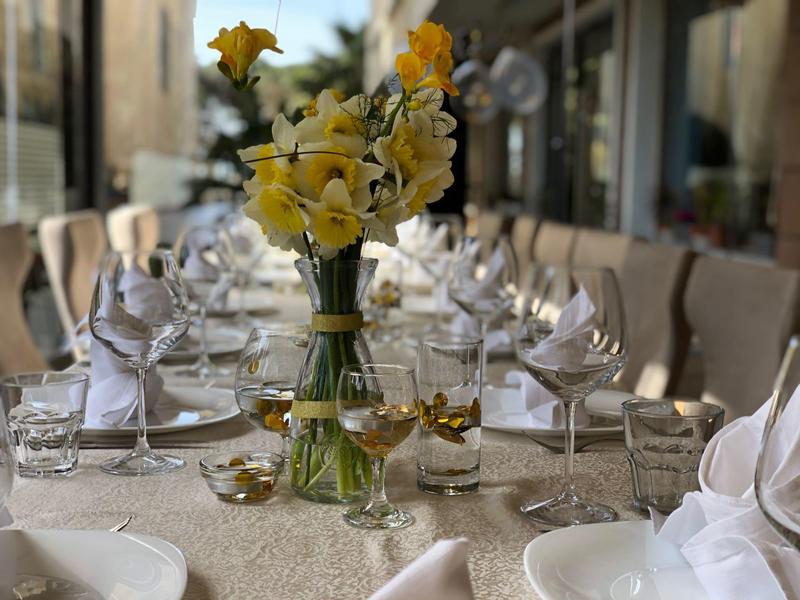 Eleganter gedeckter Tisch mit Blumenarrangement in einem Restaurant oder Hotel.