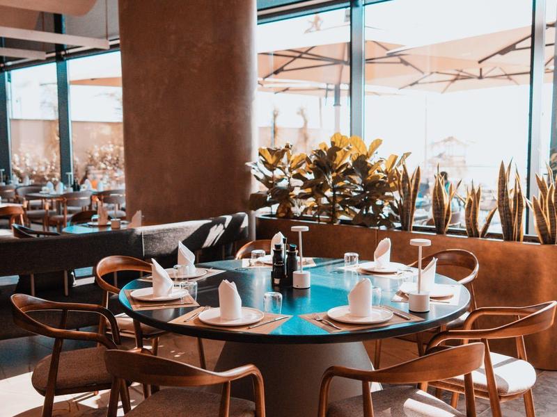 Elegant dining area with round table, modern chairs, and natural light.