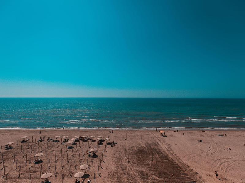 Wide beach view with blue sky and calm sea in the background