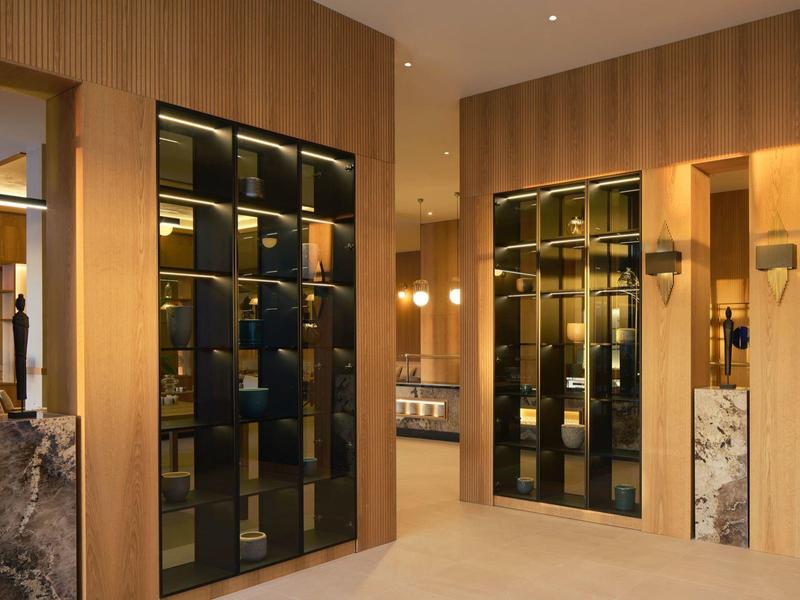 Moderner Raum mit bodentiefen Schränken, warmen Holzwänden und weichem, hellem Bodenbelag.