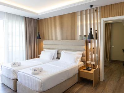 Brightly decorated hotel room with two single beds and modern interior.