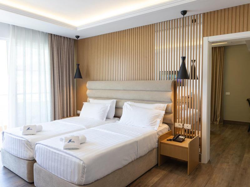 Brightly decorated hotel room with two single beds and modern interior.