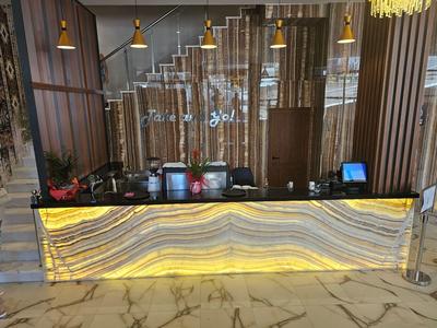 Moderner Hoteltresen mit beleuchtetem Wellenmuster und Glaswand im Hintergrund.