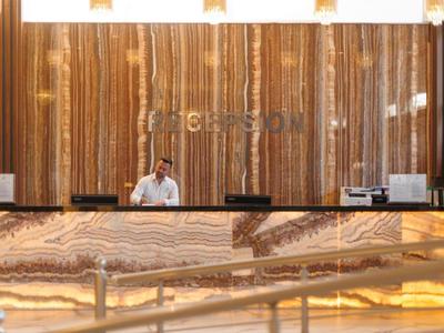 Rezeption mit beleuchtetem Marmor an der Wand und Theke in einem eleganten Hotel.