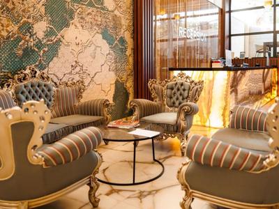 Elegante Hotellobby mit stilvollen Sesseln, Marmorfußboden und kunstvoller Wandgestaltung.