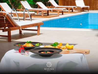 Elegantes Essen mit Vorspeisen und Getränken am Pool mit Liegestühlen.