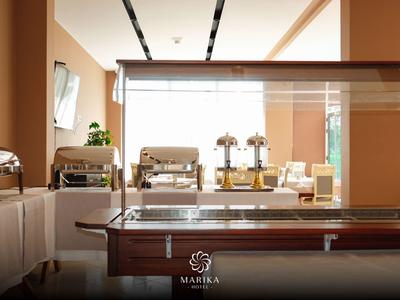 Buffetbereich mit Geschirr und Getränkespendern in einem hellen Restaurant.