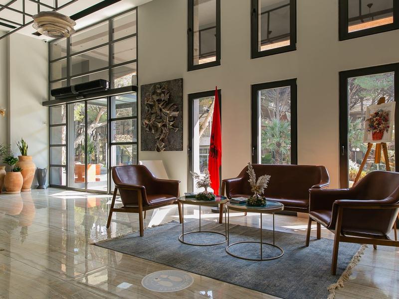 Modern hotel lobby with comfortable seating, large windows, and natural light