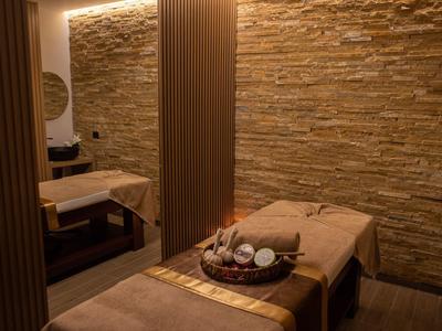 Gemütlicher Wellnessraum mit Massageliegen und entspannter Beleuchtung.