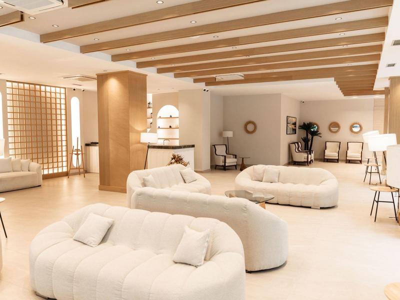 Helle und moderne Hotellobby mit weichen Sitzmöbeln und warmen Holzakzenten.