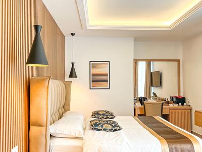 Modernes Hotelzimmer mit zwei Betten, Holzverkleidung und dekorativen Kissen.