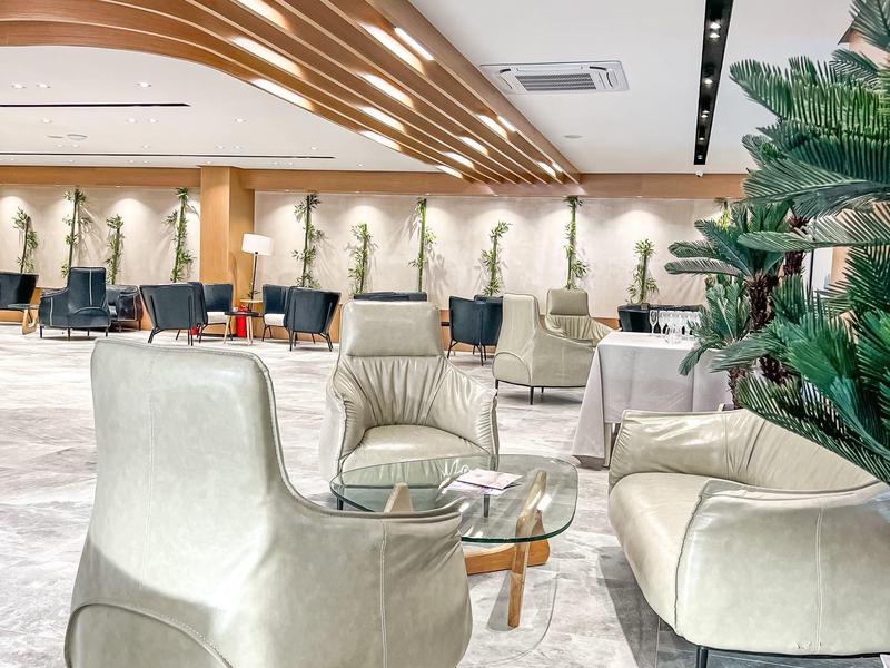 Moderne Hotellounge mit bequemen weißen Sesseln und Glasbeistelltischen auf Marmorboden