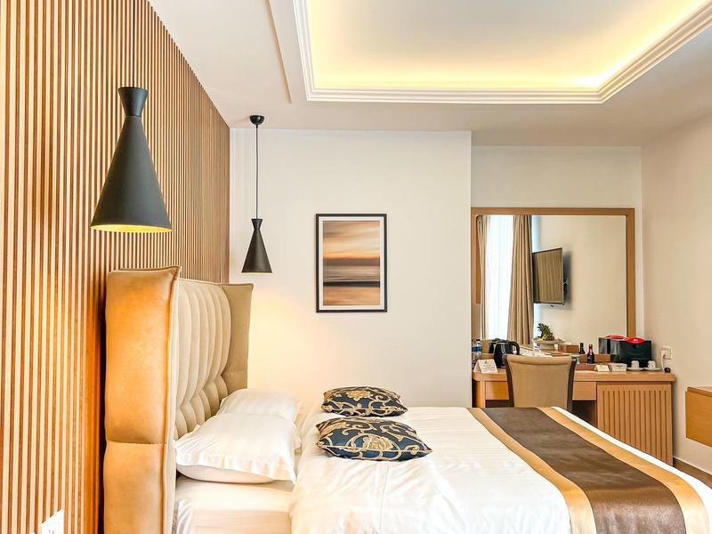 Modernes Hotelzimmer mit zwei Betten, Holzvertäfelung und stilvollen Leuchten an der Decke.