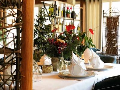 Ein gedeckter Tisch mit weißen Servietten und Blumenarrangements in einem gemütlichen Holzbetrieb.