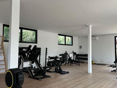 Salle de sport moderne avec équipements et grandes fenêtres dans un bâtiment hôtelier.