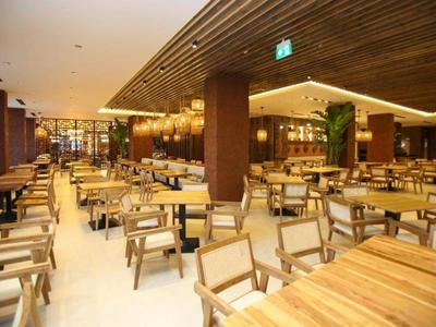 Large modern dining area with wooden chairs and tables in warm tones.