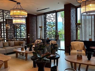 Elegancki salon hotelowy z nowoczesnymi meblami, dużymi latarniami i ozdobnymi oknami.