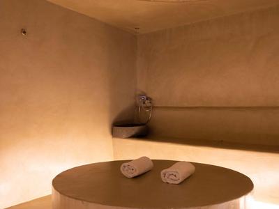 Warmer, gedämpfter Spa-Raum mit beleuchtetem runden Tisch und Handtüchern.