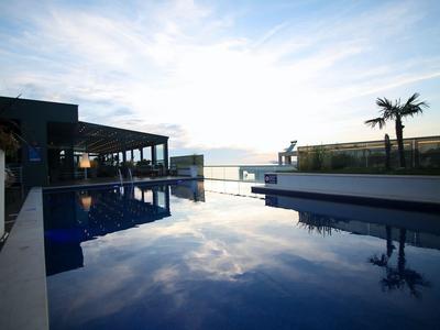 Schwimmbad mit ruhigem Wasser und Sonnenuntergang am Hotel mit Palmen