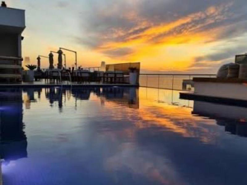 Sonnenuntergang über einem Hotelpool mit klaren Reflexionen und entspannter Atmosphäre.