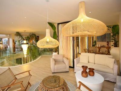 Gemütlicher Hotellobby mit moderner, natürlicher Einrichtung und großen Lampenschirmen aus Korbgeflecht