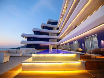 Modernes Hotel mit beleuchtetem Pool und Terrassen bei Sonnenuntergang