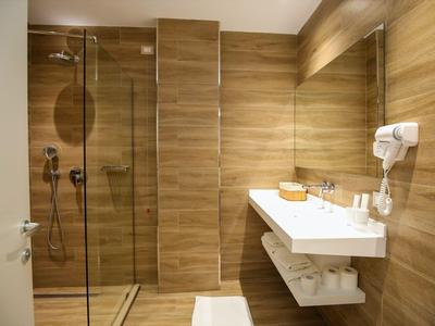 Modernes Badezimmer mit Holzverkleidung, begehbarer Dusche und Wandwaschbecken.